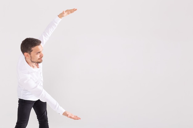 Homem bonito com barba apontando em uma direção em uma superfície branca.