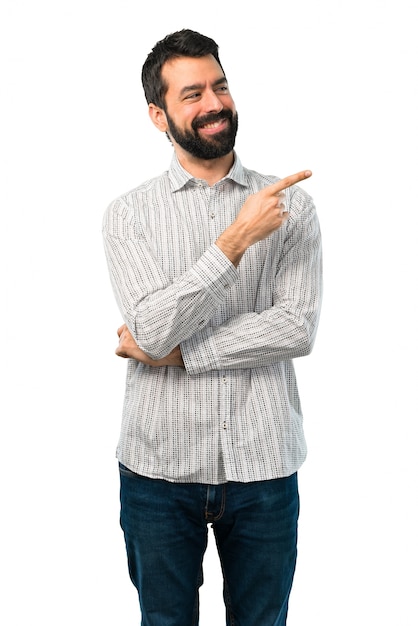 Homem bonito com barba, apontando o dedo para o lado e apresentando um produto