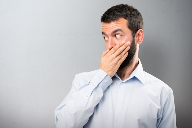 Homem bonito com barba cobrindo sua boca em fundo texturizado