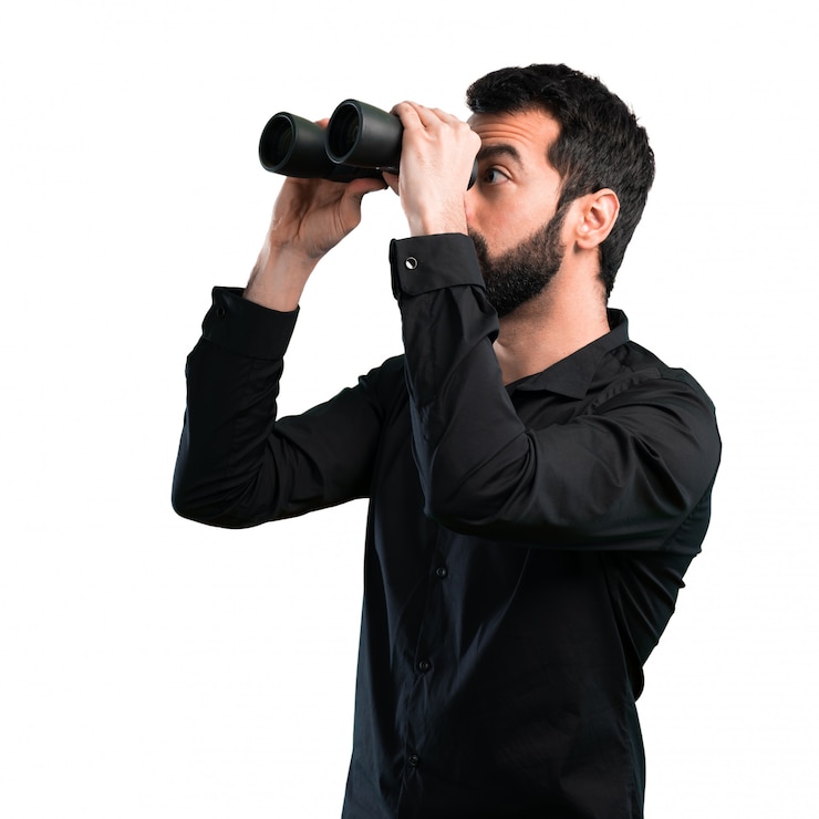 Foto homem bonito com barba com binóculos em fundo branco