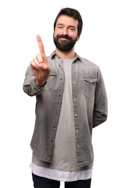 Foto homem bonito com barba contando um no fundo branco