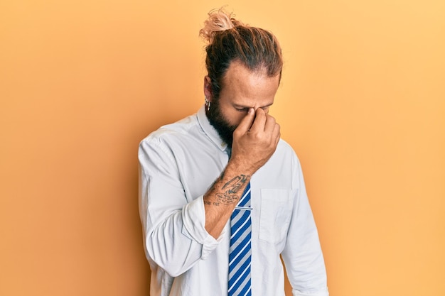 Homem bonito com barba e cabelo longo vestindo roupas de negócios cansado esfregando o nariz e os olhos sentindo fadiga e dor de cabeça estresse e conceito de frustração