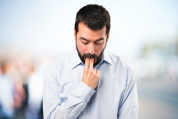 Homem bonito com barba fazendo gestos de vômito em fundo não focado