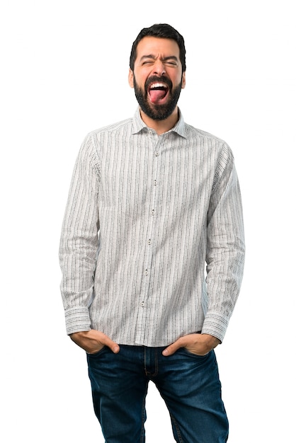 Homem bonito com barba mostrando a língua para a câmera, olhando engraçado