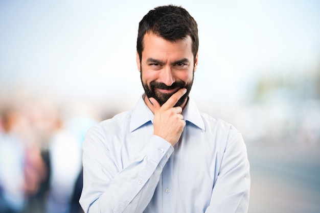 Homem bonito com barba pensando em fundo não focado