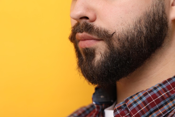 Foto homem bonito com bigode em fundo amarelo em close-up espaço para texto