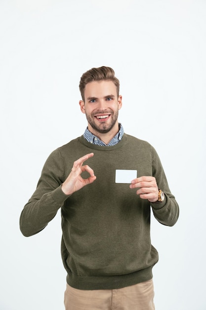 Foto homem bonito com cabelo elegante mostrando cartão de crédito isolado no espaço de cópia branco bancário on-line