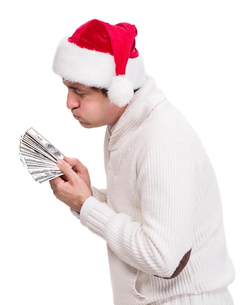 Homem bonito com chapéu de Papai Noel segurando dólares em um fundo branco