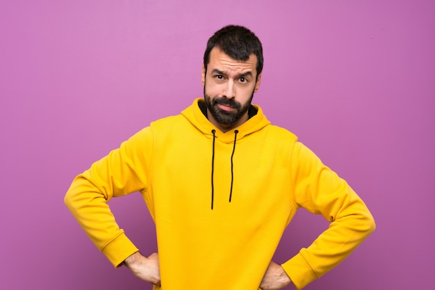 Homem bonito com moletom amarelo com raiva