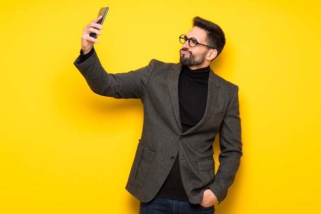 Homem bonito com óculos fazendo um selfie