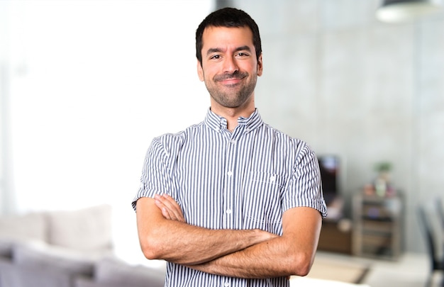 Homem bonito com os braços cruzados dentro da casa