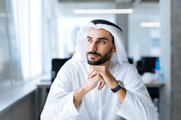 Homem bonito com prato dasha trabalhando em seu escritório de negócios de Dubai
