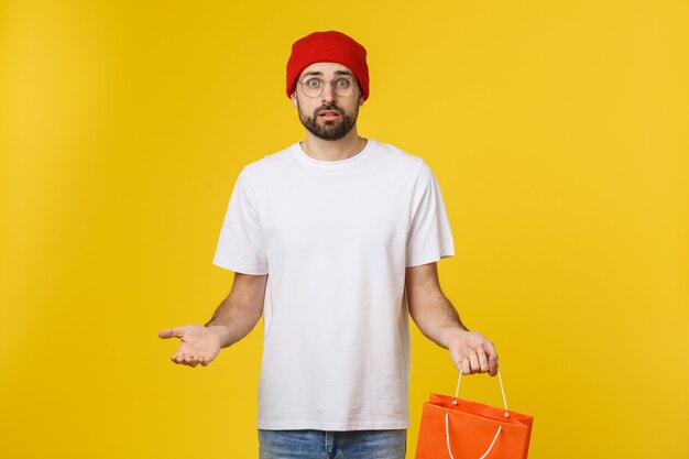 Homem bonito com saco de compras, sentindo-se preocupado e sério.