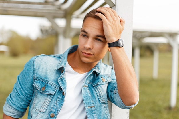 Homem bonito com um relógio preto na natureza