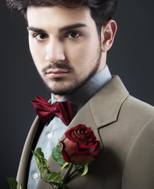 Homem bonito com uma única rosa vermelha
