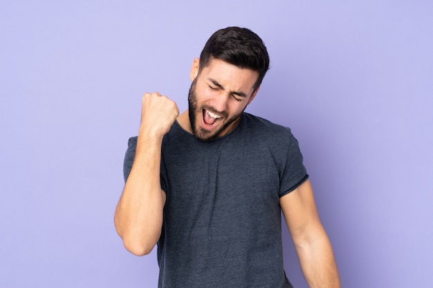 homem bonito comemorando uma vitória sobre roxo