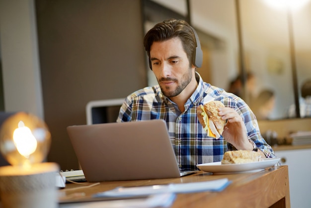 Homem bonito comer o almoço no trabalho