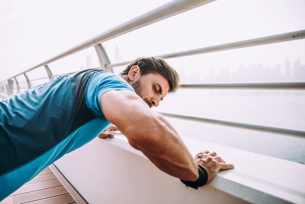 Foto homem bonito dando certo e exercícios diferentes ao ar livre