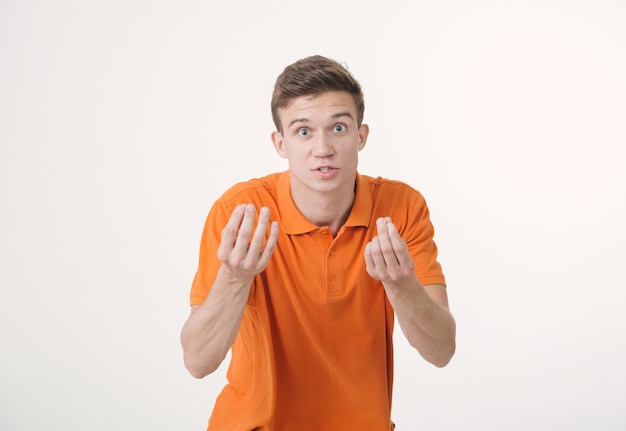 Homem bonito de cabelos castanhos vestindo uma camisa laranja e parecendo zangado