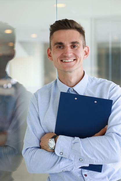 Homem bonito de camisa e pasta no escritório