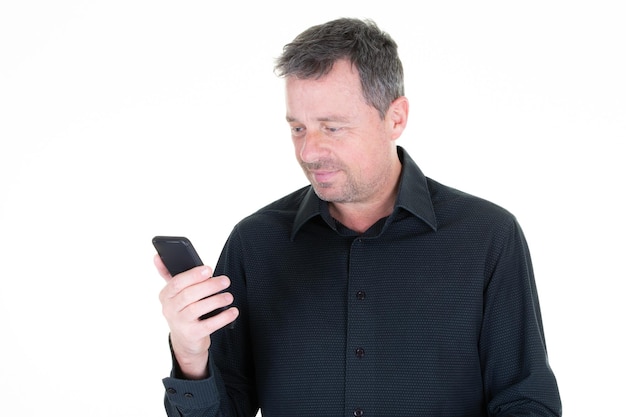 Homem bonito de camisa preta está olhando para a tela de seu telefone smartphone