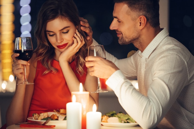 Foto homem bonito de ferro sua namorada enquanto jantar romântico à noite