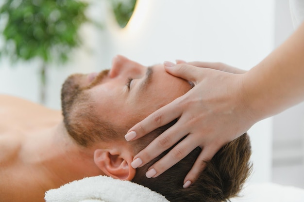 Homem bonito de meia-idade a desfrutar de uma massagem relaxante com óleos