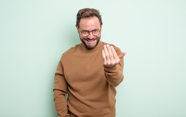 Homem bonito de meia-idade se sentindo feliz, bem-sucedido e confiante, enfrentando um desafio e dizendo: traga-o! ou te acolhendo