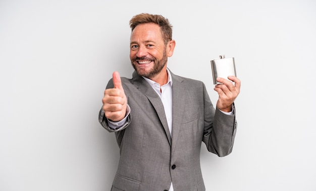 Homem bonito de meia-idade, sentindo-se orgulhoso, sorrindo positivamente com o polegar para cima. conceito de frasco de álcool