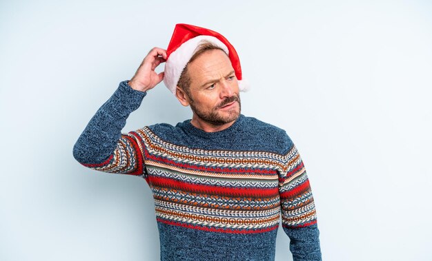 Homem bonito de meia-idade, sorrindo alegremente e sonhando acordado ou duvidando. conceito de natal