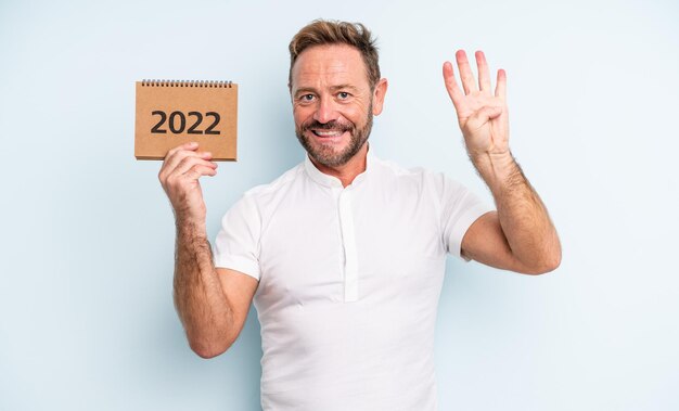 Homem bonito de meia-idade, sorrindo e parecendo amigável, mostrando o número quatro. Conceito de calendário 2022