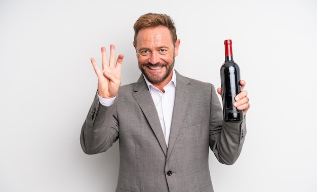 Foto homem bonito de meia-idade sorrindo e parecendo amigável, mostrando o número quatro. conceito de garrafa de vinho