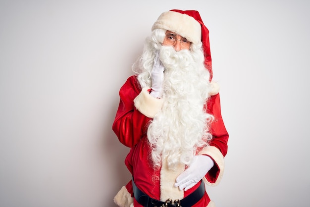 Homem bonito de meia-idade vestindo fantasia de Papai Noel em pé sobre fundo branco isolado, tocando a boca com a mão com expressão dolorosa por causa de dor de dente ou doença dentária nos dentes Conceito de dentista