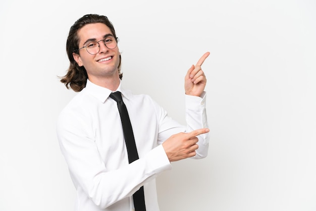 Homem bonito de negócios isolado no fundo branco, apontando o dedo para o lado e apresentando um produto
