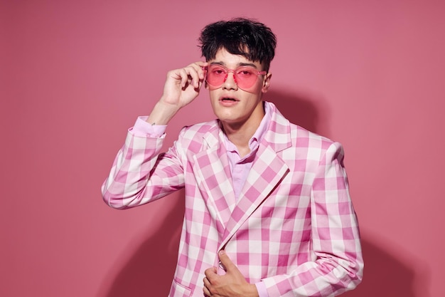 Homem bonito de óculos rosa blazer rosa posando fundo isolado de estúdio inalterado