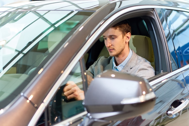 Homem bonito dentro de carro novo