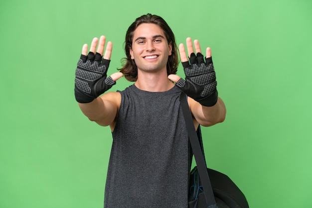 Homem bonito do esporte jovem isolado no fundo croma verde contando dez com os dedos