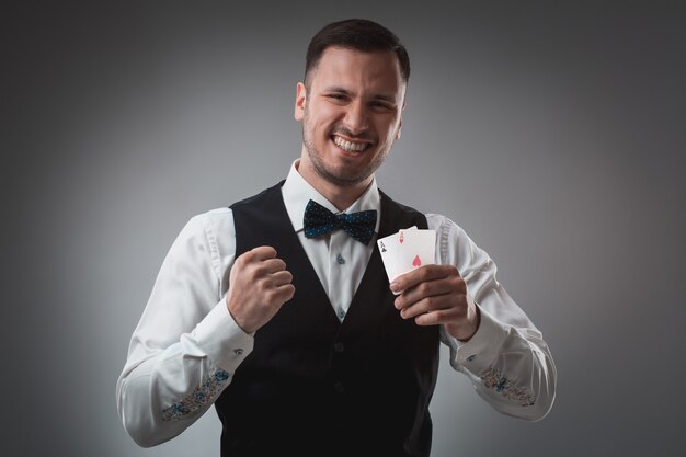 Homem bonito e confiante segurando cartas, olhando para a câmera.