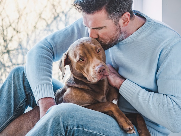 Homem bonito e um filhote de cachorro encantador. fechar-se