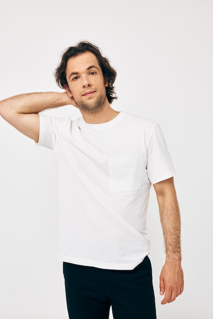 Homem bonito em um fundo branco de gesto de mão de camiseta branca