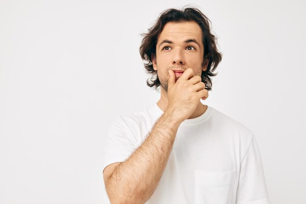 Homem bonito em um gesto de mão de camiseta branca Estilo de vida inalterado