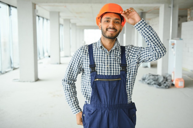 Homem bonito engenheiro asiático ou arquiteto com capacete de segurança branco no canteiro de obras em pé na construção civil moderna Trabalhador homem asiático trabalhando na construção do projeto