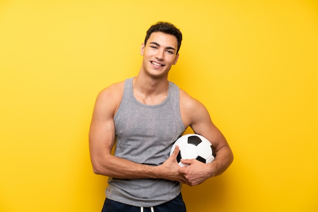 Homem bonito esporte mais isolado com uma bola de futebol