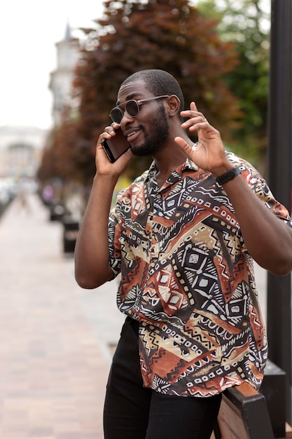 Foto homem bonito falando ao telefone ao ar livre