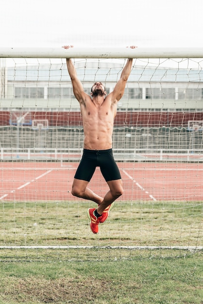 Homem bonito fazendo abdominais ao ar livre.