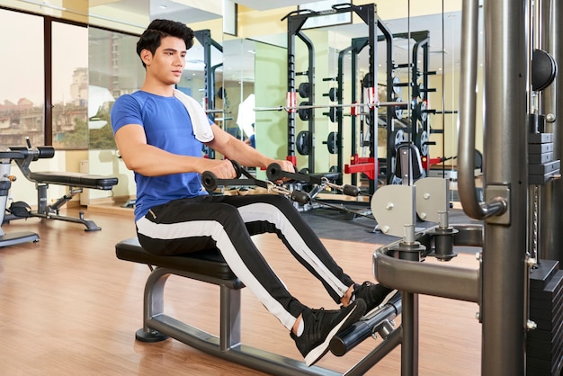 Homem bonito fazendo exercícios na academia