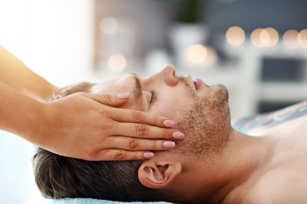 Foto homem bonito fazendo massagem em salão de spa