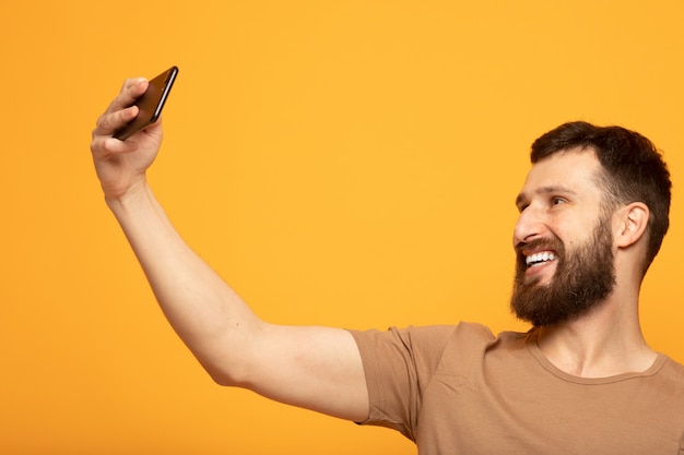 Homem bonito feliz usando um smartphone