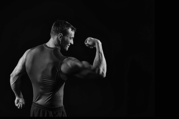 Homem bonito fisiculturista com treinamento de corpo musculoso no ginásio