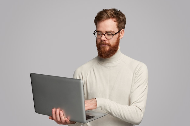 Homem bonito focado usando laptop